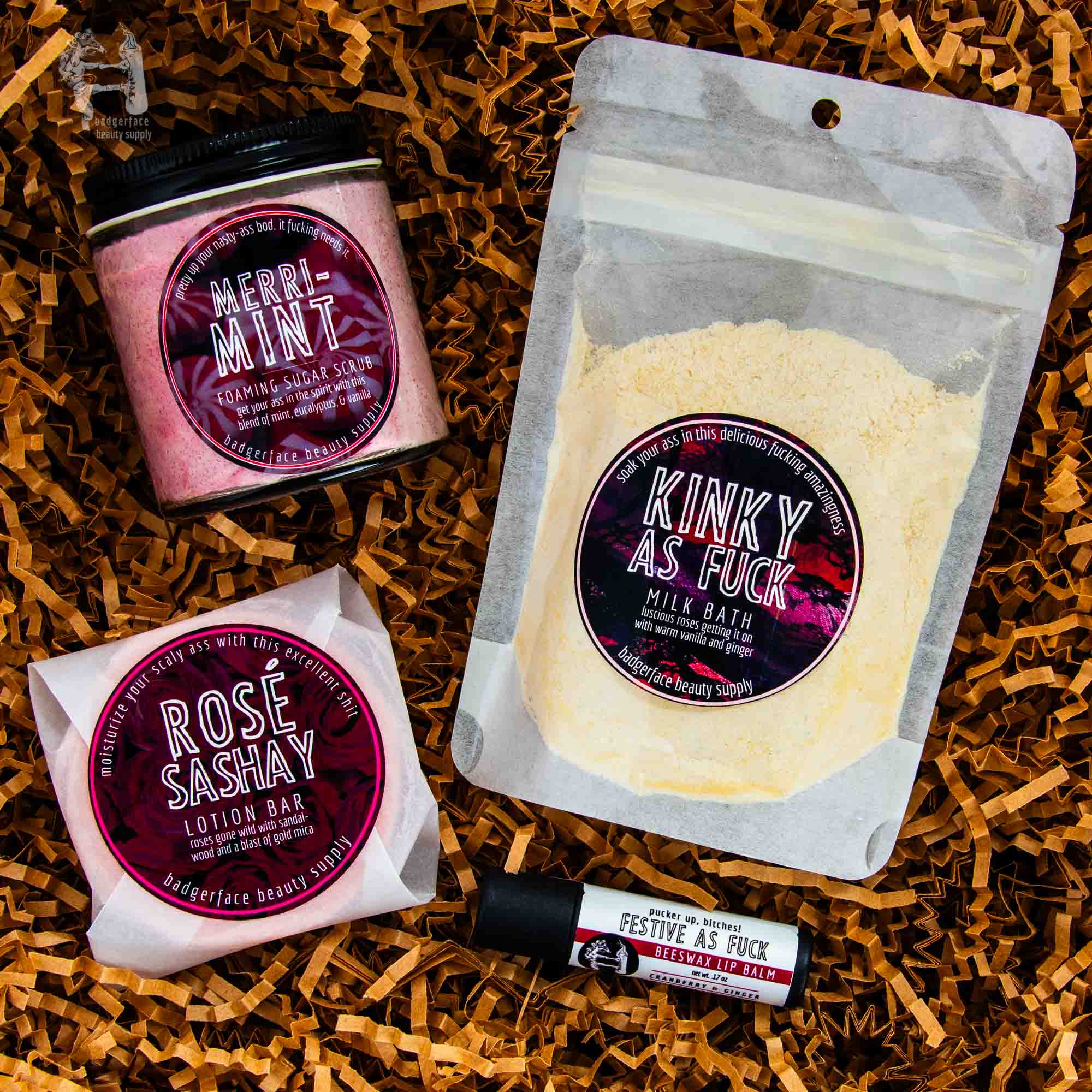 Christmas Gift Box for Women - Plasticology featuring a sugar scrub, milk bath, lotion bar, and lip balm on shredded paper background.